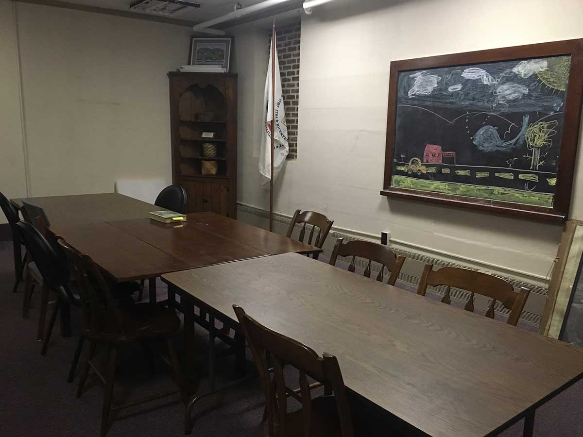 Interior shot of the Williamsport Small Conference Room with table, chairs and blackboard