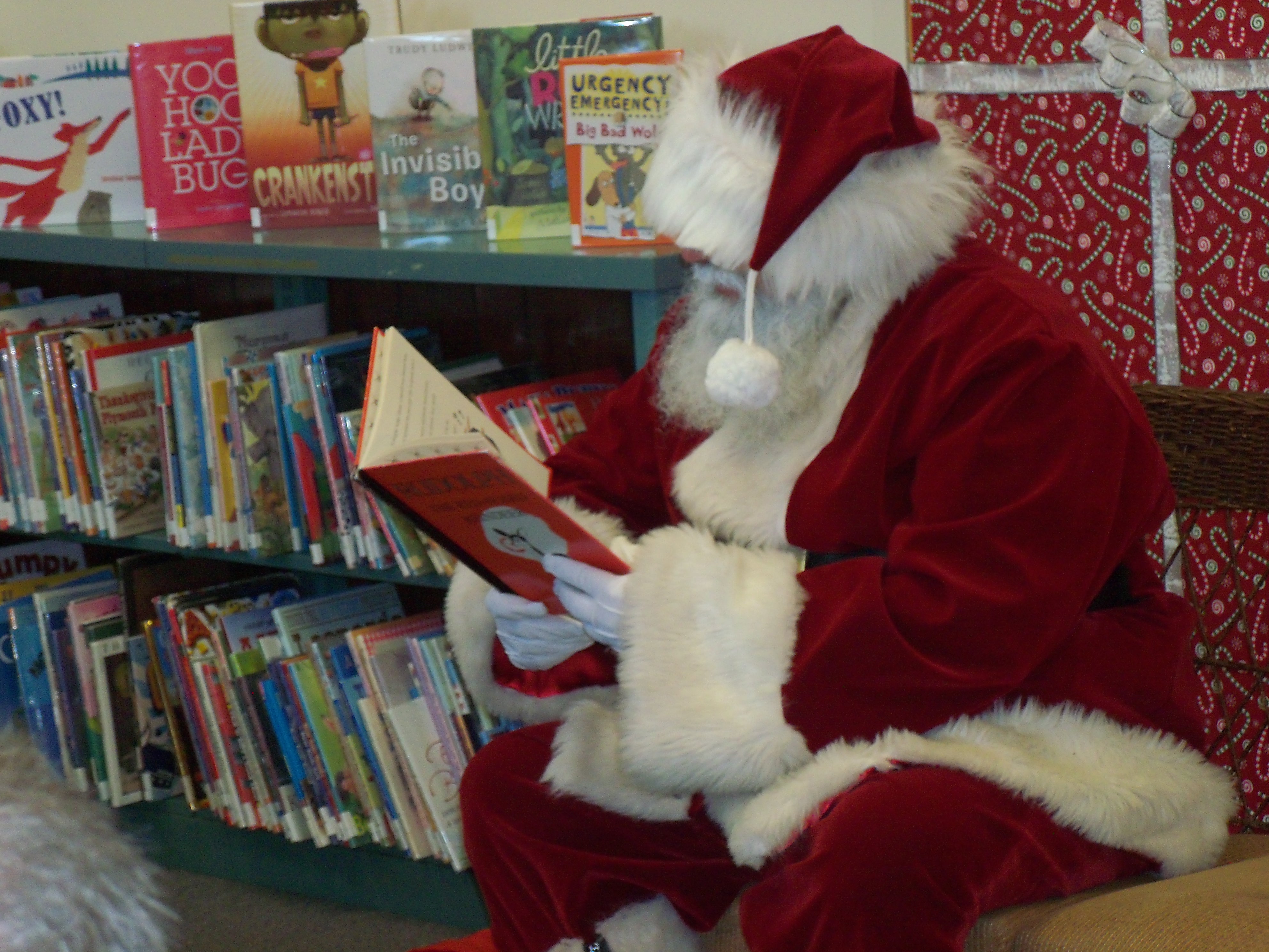 Santa in the library reading a book