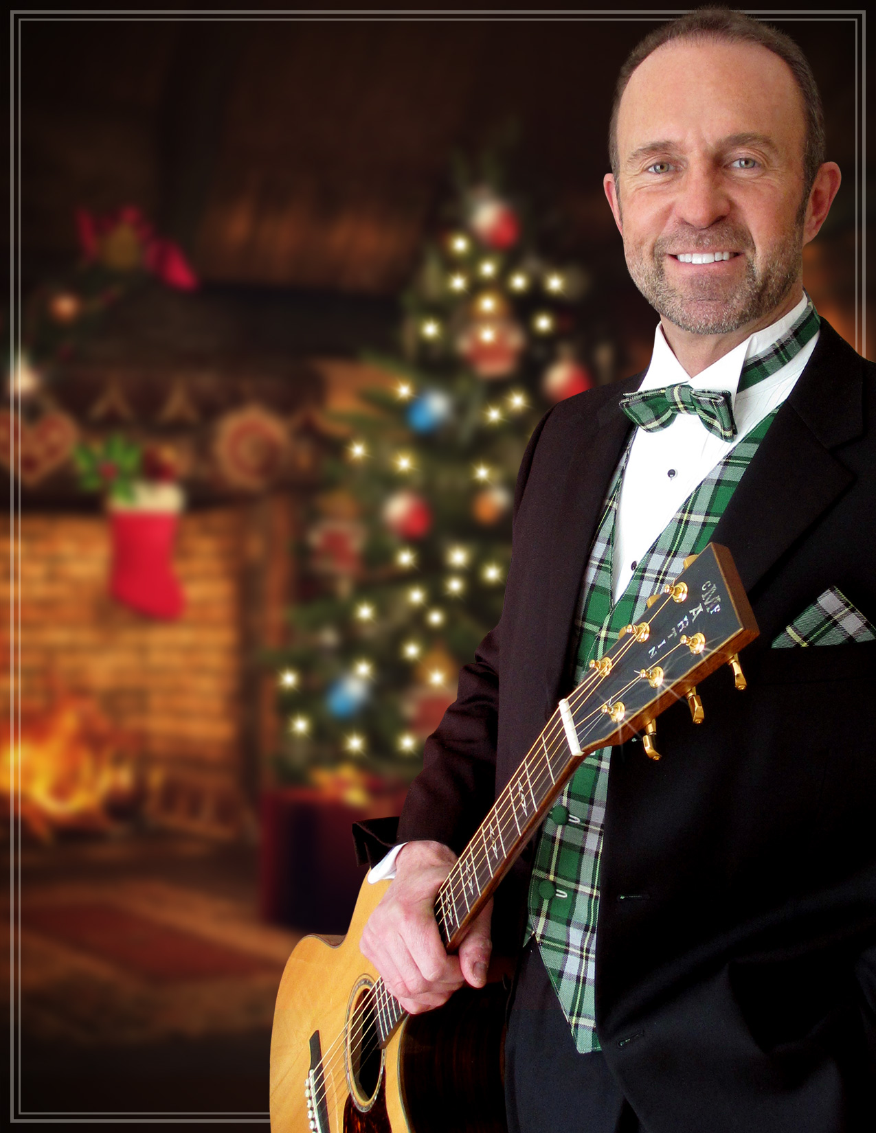 Image of musician holding guitar with lit Christmas tree in background.