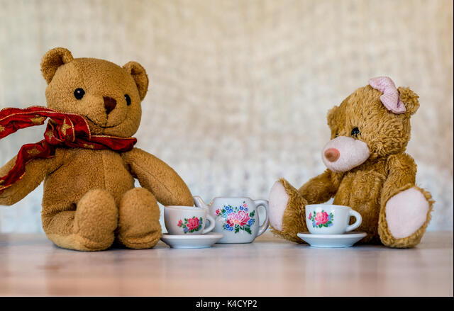 Two teddy bears enjoying a spot of tea together.