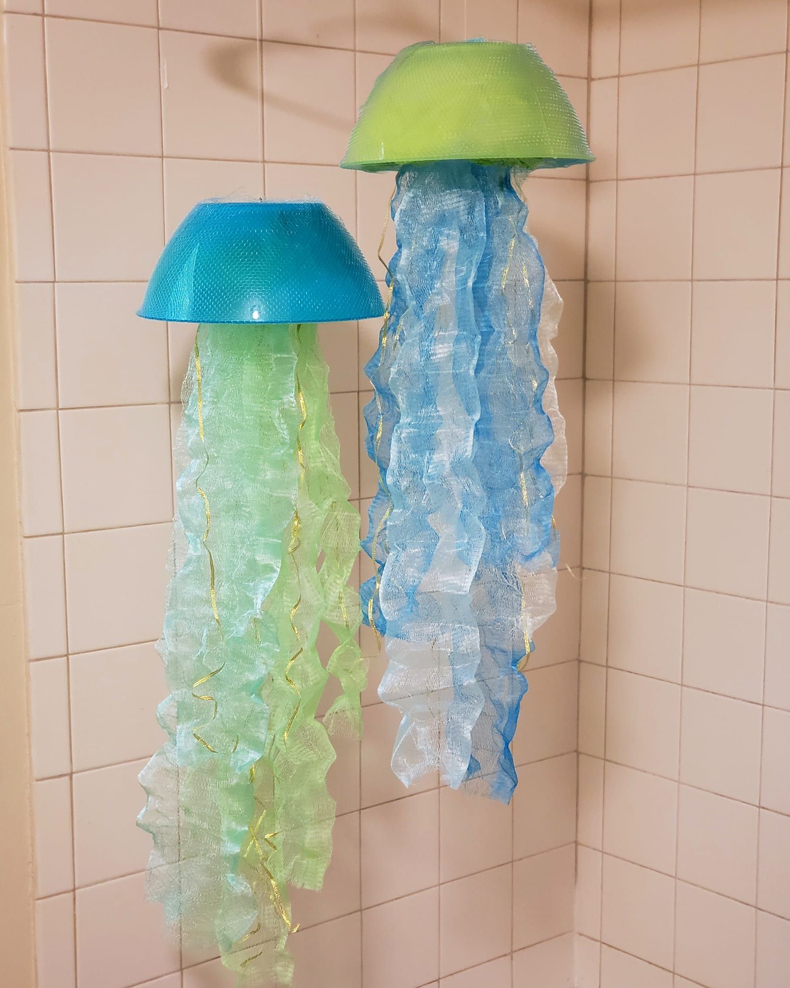 Two green and blue hanging lamps that look like jellyfish. 