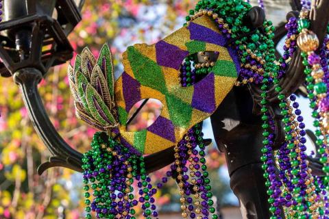 Mardi gras mask with beads on light pole