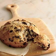 Loaf of Irish Soda Bread with chocolate chips on a wooden cutting board