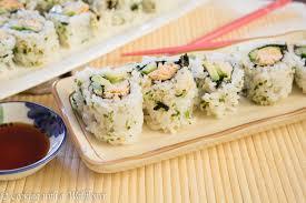 plate of spicey chicken sushi with sauce and chopsticks