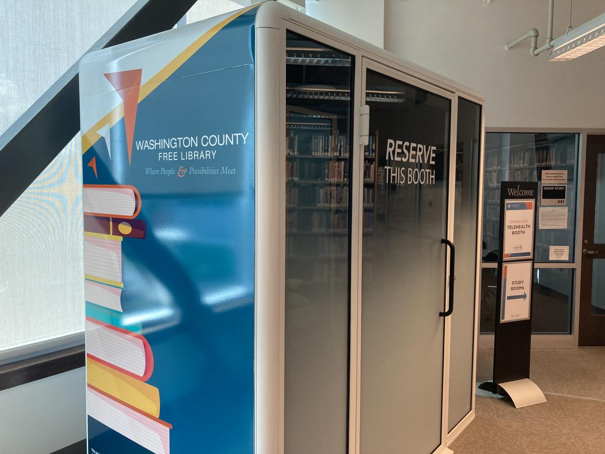 Telehealth Booth with WCFL logo and books on the outside of the booth